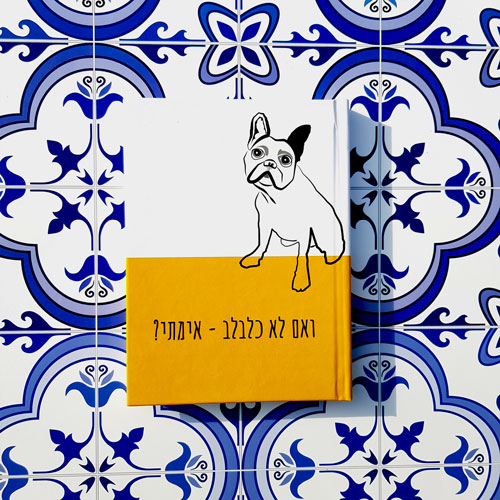 מחברת מעוצבת עם ציור של כלב, מצולמת על רקע אריחים כחולים